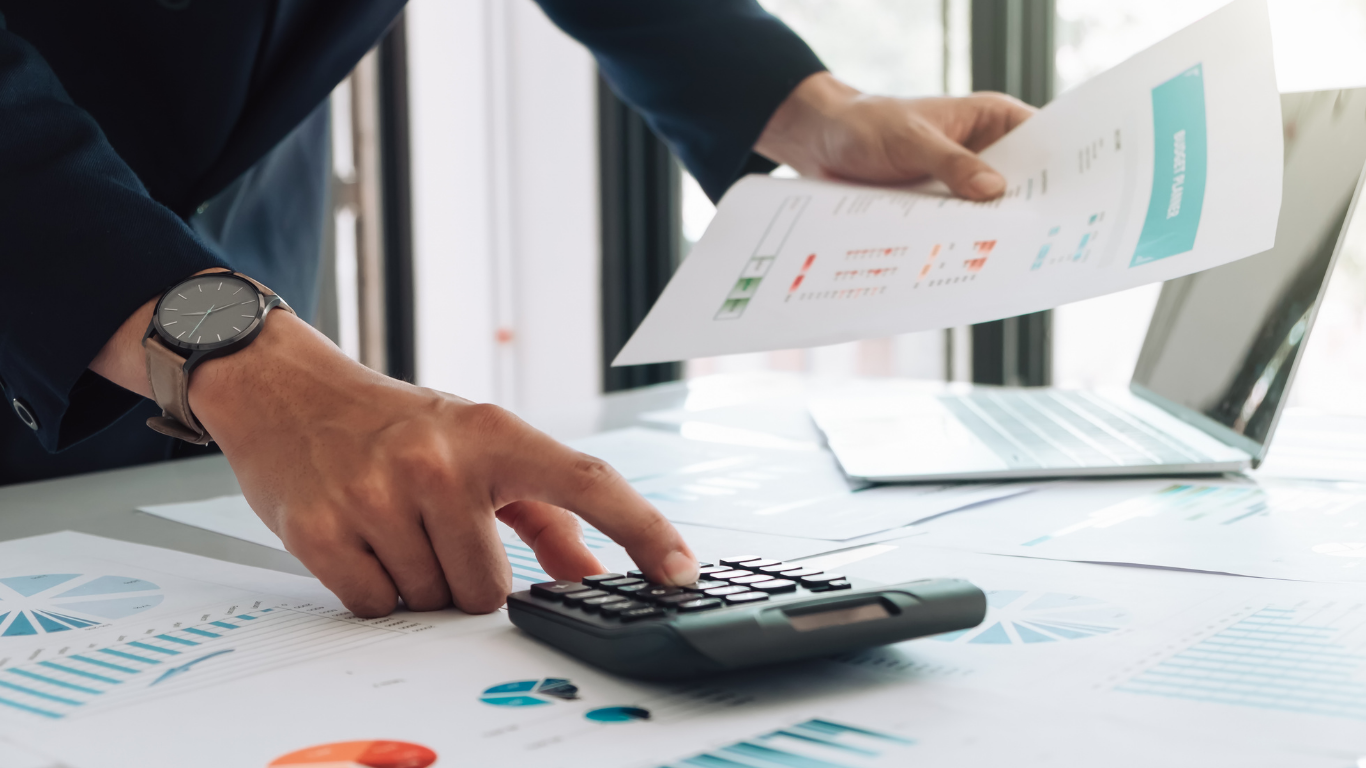 Informe fiscal de empresa con gráficos y calculadora sobre la mesa